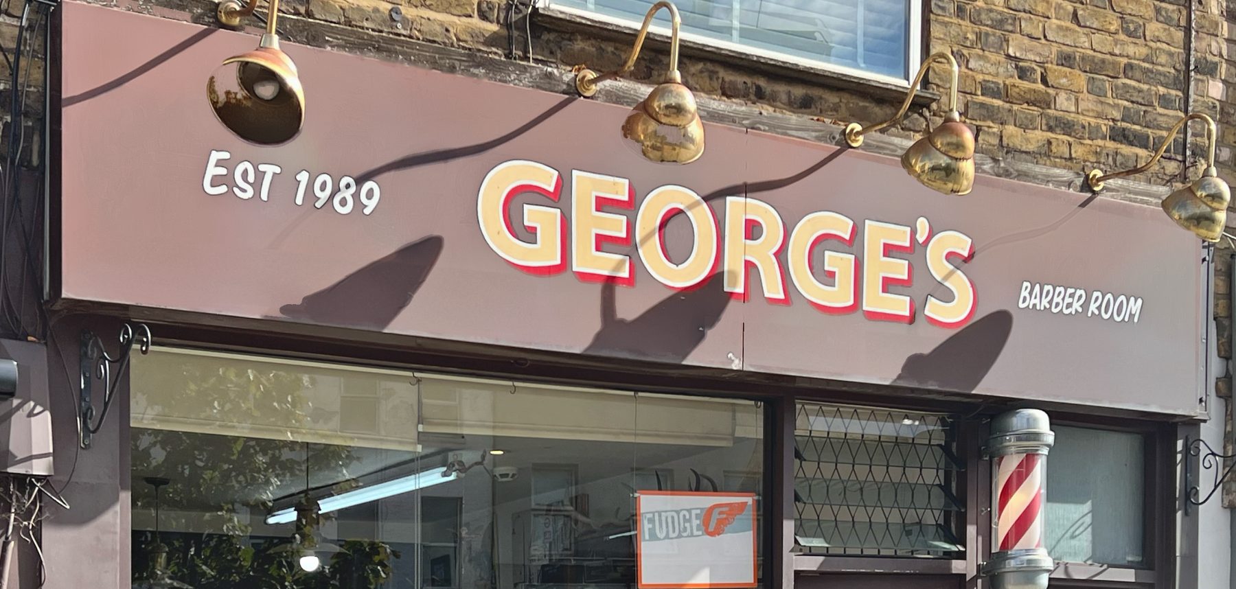 Hand-lettered George's Barber Room sign with brass lamps, Kentish Town Road